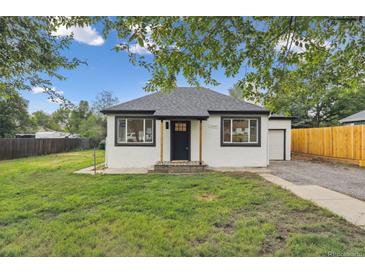 Charming single-story home featuring a well-maintained lawn, black trim, and inviting curb appeal at 11842 W 14Th Ave, Lakewood, CO 80401
