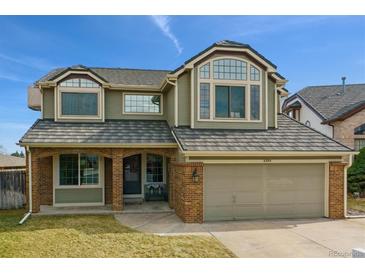 Charming two-story home with brick accents, attached garage, and well-maintained lawn in a friendly neighborhood at 8293 S Reed St, Littleton, CO 80128