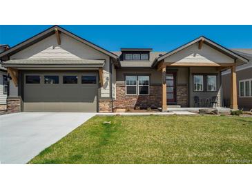 Charming home with a stone-accented facade, covered porch, and well-manicured lawn at 16277 Talons Bluff Ln, Monument, CO 80132