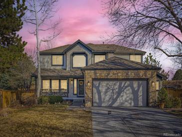 Charming two-story home featuring a stone-accented garage and inviting front porch at 10672 Wintersweet Pl, Parker, CO 80134