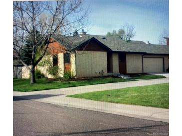 Single story home boasts mature trees, a green lawn and a private entrance at 671 Brentwood St, Lakewood, CO 80214