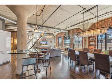 Spacious living area with exposed brick, concrete ceilings, and a large dining table for entertaining at 1863 Wazee St # 6B, Denver, CO 80202