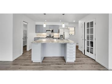 Modern kitchen featuring a large island with a granite countertop and stainless steel appliances at 641 E 104Th Pl, Northglenn, CO 80233