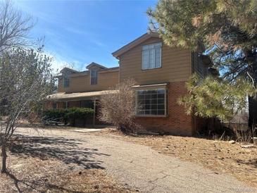 Two story home with brown wood and brick and dormer windows on a sunny day at 5449 S Locust St, Greenwood Village, CO 80111