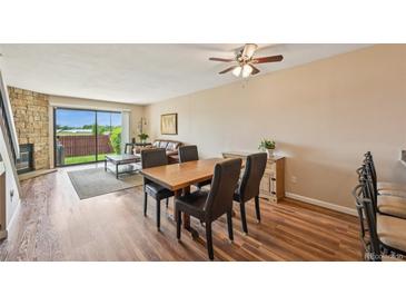 Cozy living room featuring hardwood floors, stone fireplace, and access to the backyard at 7474 E Arkansas Ave # 13-02, Denver, CO 80231