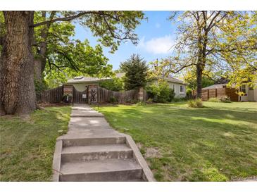 Charming home with a well-maintained lawn, mature trees, and a welcoming walkway, creating inviting curb appeal at 4567 Grove St, Denver, CO 80211