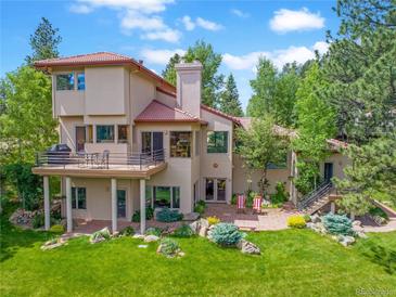 Spacious home featuring a large balcony, a patio, and well-manicured landscaping, creating an inviting outdoor living space at 2398 Bitterroot Ln, Golden, CO 80401