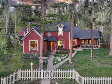 Charming red two-story home with a white picket fence and a landscaped front yard at 102 S High St, Breckenridge, CO 80424
