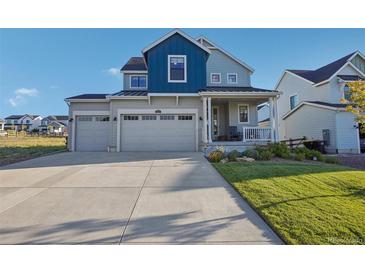 Two-story house with gray and blue exterior, three car garage, and landscaped yard at 1123 Williams Loop, Elizabeth, CO 80107