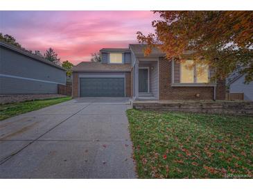 Charming home with a well-maintained lawn, two-car garage, and beautiful landscaping at 1064 Lily Ct, Highlands Ranch, CO 80126