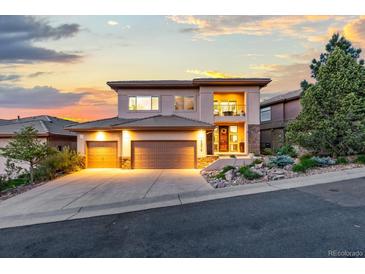 Stunning two-story home with a three-car garage, landscaped yard, and balcony showcasing an amazing sunset at 6874 Raspberry Run, Littleton, CO 80125