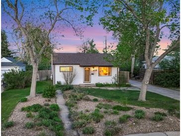 Charming single story home featuring beautiful landscaping with mature trees and flowering plants at 2666 S Green Ct, Denver, CO 80219