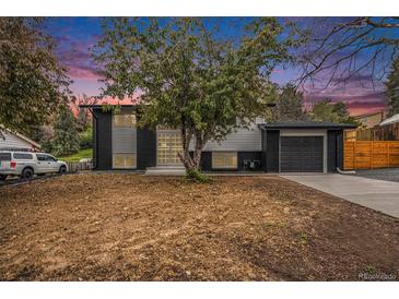 Charming split-level home showcasing a black and white exterior, attached garage, and front yard at 11172 W Exposition Dr, Denver, CO 80226