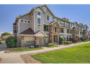 Well-maintained condo building with stone accents, manicured lawn, and inviting walkways at 12711 Colorado Blvd # 607F, Thornton, CO 80241