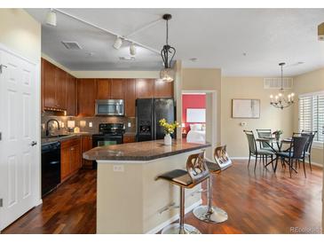 Modern kitchen with wooden cabinets, granite countertops, and stainless steel appliances at 2662 S Cathay Way # 112, Aurora, CO 80013