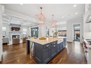 Modern kitchen with a large island, white and dark blue cabinets, and a farmhouse sink at 1131 S York St, Denver, CO 80210