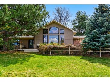 Inviting home showcasing large window, lush greenery, and well-maintained lawn at 182 Ridge Rd, Boulder, CO 80303