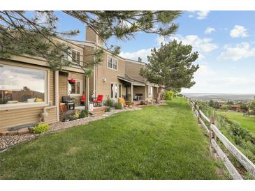 Sprawling backyard featuring a lush lawn, patio, and scenic views from the edge of the property at 6948 Buckskin Dr, Littleton, CO 80125