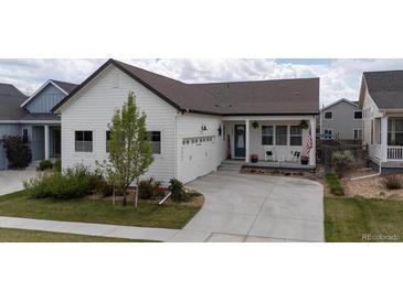 Charming single-Gathering home with a white exterior, a well-manicured lawn, and a two-car garage at 4422 Mt Shavano St, Brighton, CO 80601
