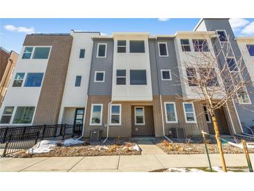 Contemporary townhome with mixed brick and gray siding, complemented by a landscaped front yard with a walkway at 14261 Currant St, Broomfield, CO 80020