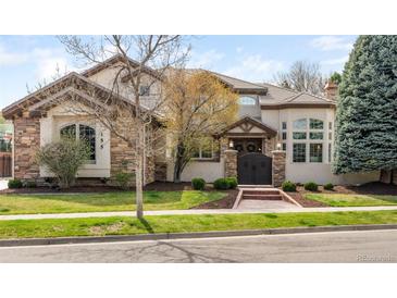 Elegant two-story home featuring stone accents, a symmetrical design, and a beautifully landscaped front yard at 155 S Poplar St, Denver, CO 80230