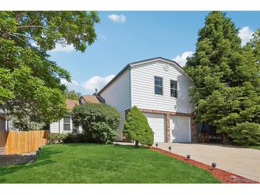 Two-story home featuring a two-car garage, landscaped yard, and mature trees, perfect for suburban living at 5612 S Jebel Way, Centennial, CO 80015
