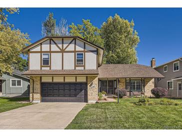 Charming Tudor-style home with well-maintained lawn and a two-car garage in a suburban neighborhood at 10365 E Weaver Cir, Englewood, CO 80111