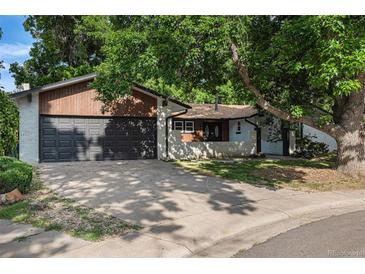 Charming single-story home with a brick facade, mature trees, and a two-car garage at 10051 E Walsh Pl, Denver, CO 80247