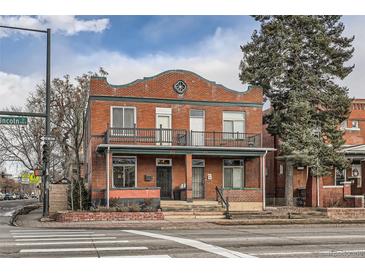 Charming brick two-story home with a balcony and a well-maintained front yard at 300 S Lincoln St, Denver, CO 80209