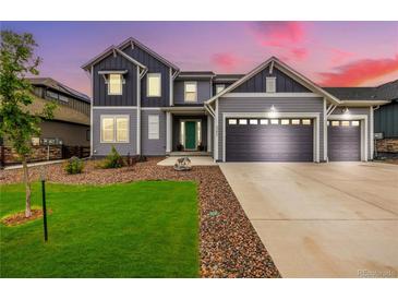 Charming two-story home featuring a three-car garage and a well-manicured front yard with lush green grass at 3256 Offbeaten Pl, Castle Rock, CO 80108