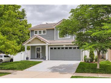 Charming two-story home featuring a well-maintained lawn, gray siding, and an attached two-car garage at 5570 Nepal St, Denver, CO 80249