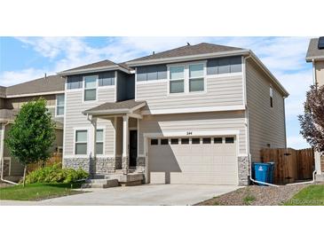 Charming two-story home featuring manicured landscaping and a spacious two-car garage at 244 Chipeta Way, Lochbuie, CO 80603