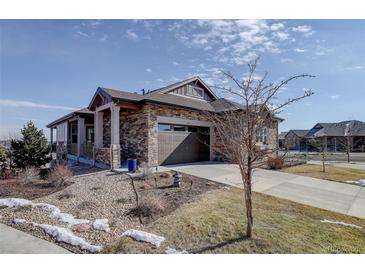 Charming stone-accented home with well-maintained landscaping and a two-car garage at 24963 E Phillips Pl, Aurora, CO 80016