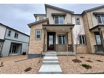Charming townhome with stone accents, covered porch, and well-maintained gravel landscaping at 6668 N Nepal Ct, Aurora, CO 80019