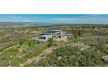 Stunning modern home boasts sleek design and breathtaking mountain views from its hilltop location at 1175 Ridge Oaks Dr, Castle Rock, CO 80104