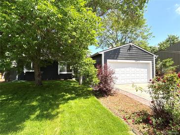 Charming home featuring a well-maintained lawn, mature trees, and a two-car garage at 18073 E Belleview Pl, Centennial, CO 80015