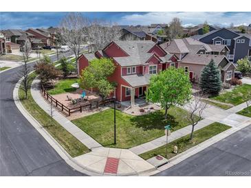 Well-manicured lawn surrounds this beautiful two-story home with wood fence and mature trees on a corner lot at 22965 Allendale Ave, Parker, CO 80138