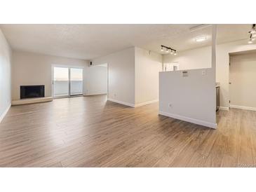 Bright living room with fireplace and sliding glass doors leading to a balcony at 2880 S Locust St # 704N, Denver, CO 80222