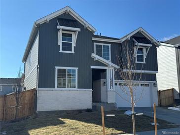 Charming two-story home featuring a modern exterior with a two-car garage and manicured lawn on a clear day at 16654 W 93Rd Way, Arvada, CO 80007