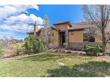 Attractive home featuring manicured lawns, stone accents, and professional landscaping for enhanced curb appeal at 7850 Vallagio Ln, Englewood, CO 80112