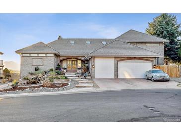 Beautiful brick home with attached garage, manicured lawn, and gorgeous stone paver walkway at 4121 S Allison St, Denver, CO 80235