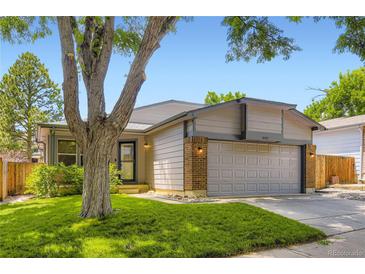 Charming one-story home with lush lawn, mature tree, and two car garage at 8432 S Upham Way, Littleton, CO 80128
