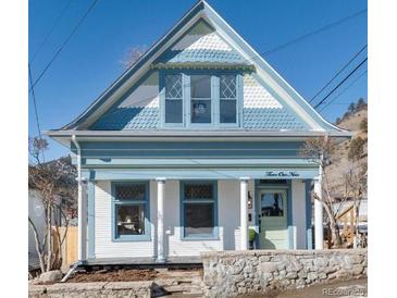 Charming two-story home with light blue accents and a stone facade at 319 13Th Ave, Idaho Springs, CO 80452