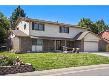 Charming two-story home featuring a lush lawn, well-maintained landscaping, and a welcoming entrance at 5425 Camargo Rd, Littleton, CO 80123