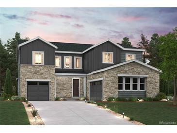 Inviting two-story home with stone and gray siding, featuring a two-car garage and manicured front lawn at 2537 Lupton Ln, Lafayette, CO 80026