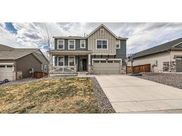 Inviting two-story home featuring a covered porch, neutral colors, and a well-maintained front yard at 935 Peach Leaf Ln, Elizabeth, CO 80107