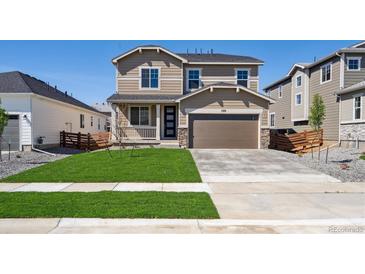 Inviting two-story home with a manicured lawn, a two-car garage, and a charming front porch at 1331 Rock Cliff Ave, Erie, CO 80516