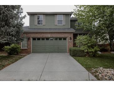 Two-story home boasts an attached garage, brick accents, a driveway, and mature landscaping at 11538 Hudson St, Thornton, CO 80233