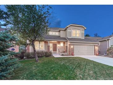 Lovely two-story home featuring a well-kept lawn, a two-car garage, and inviting curb appeal at 7454 Snow Lily Pl, Castle Pines, CO 80108