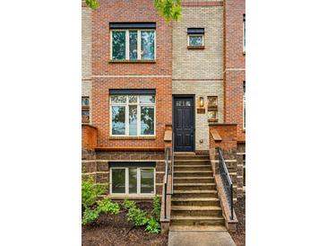 Charming brick townhome with a black front door and well-maintained landscaping at 2319 Decatur St, Denver, CO 80211